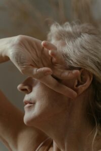 pexels-photo-8625554-8625554 An intimate portrait of an elderly woman with her hand gently covering her face, captured in soft, muted tones.